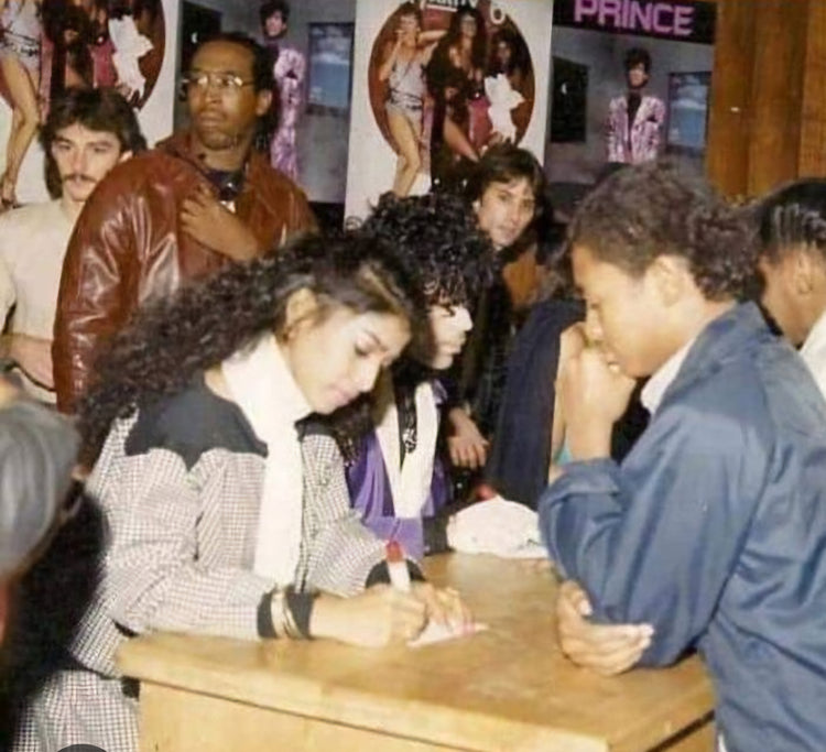 Prince sitting at table signing autographs photo Boston