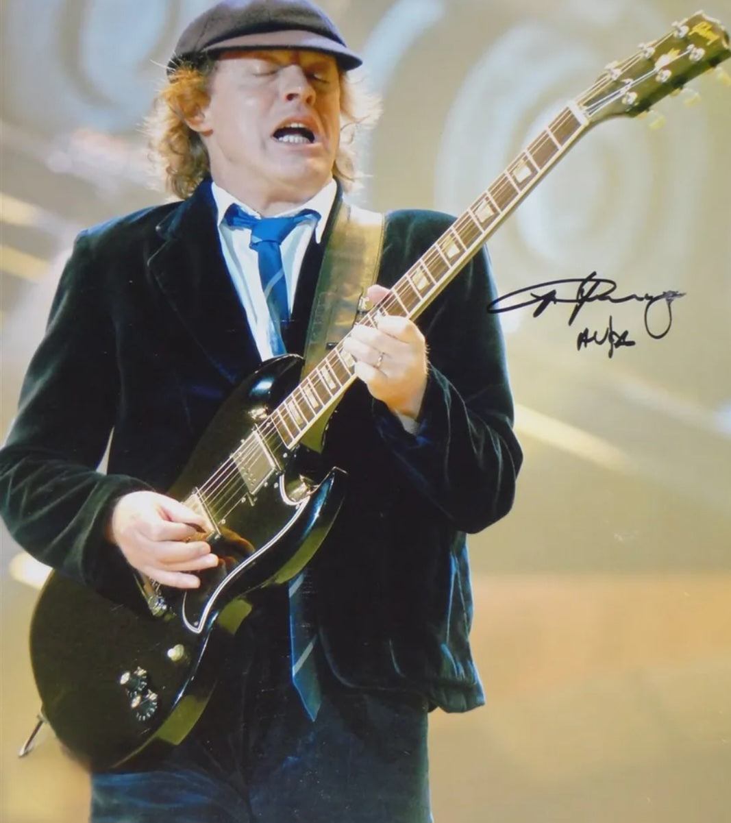 Angus Young signed photo on stage playing guitar