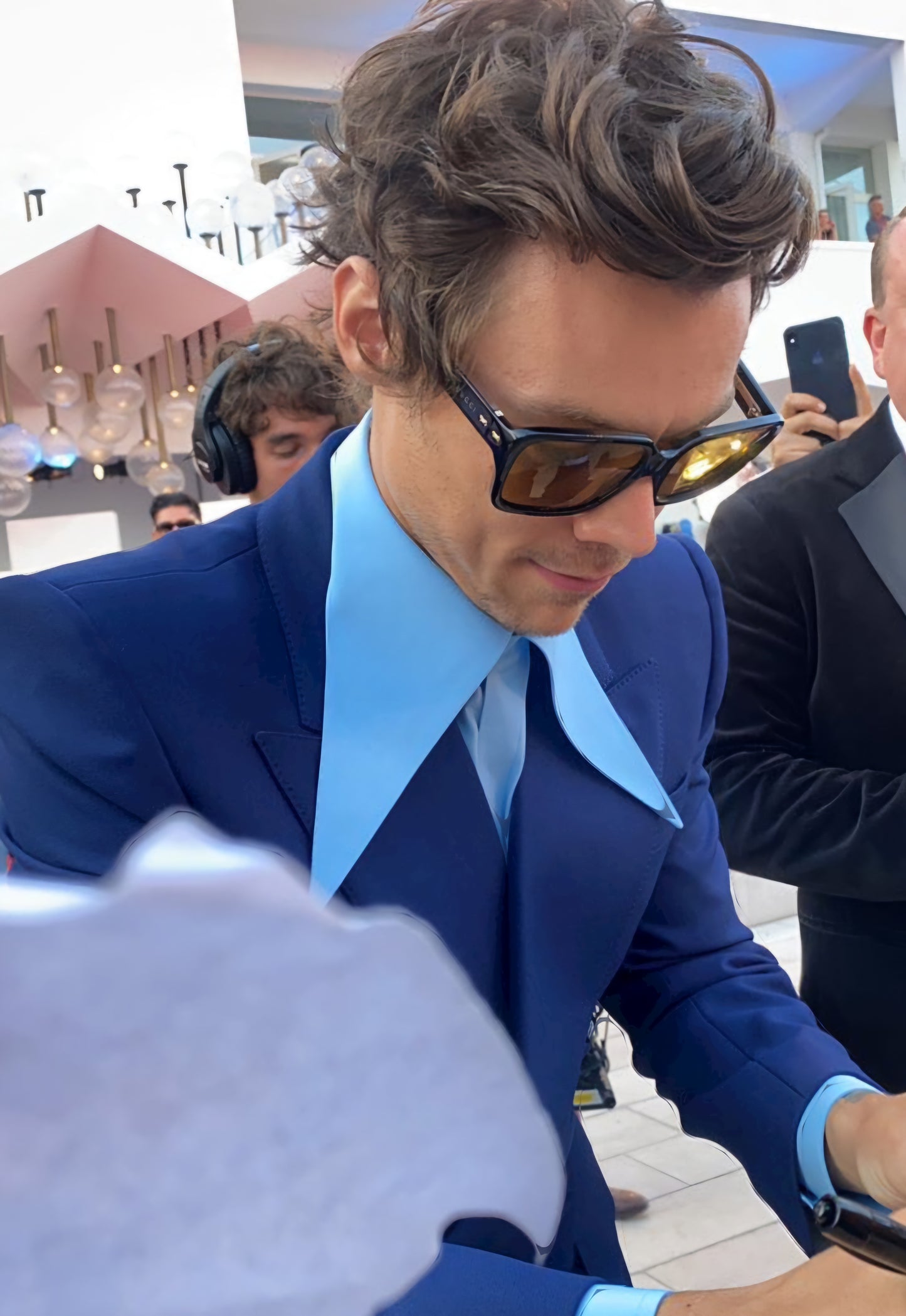 Harry Styles signing autograph for fan in blue suit