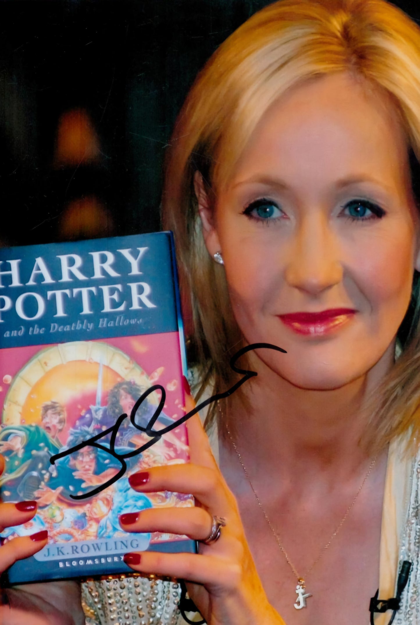 JK Rowling signed photo holding up book