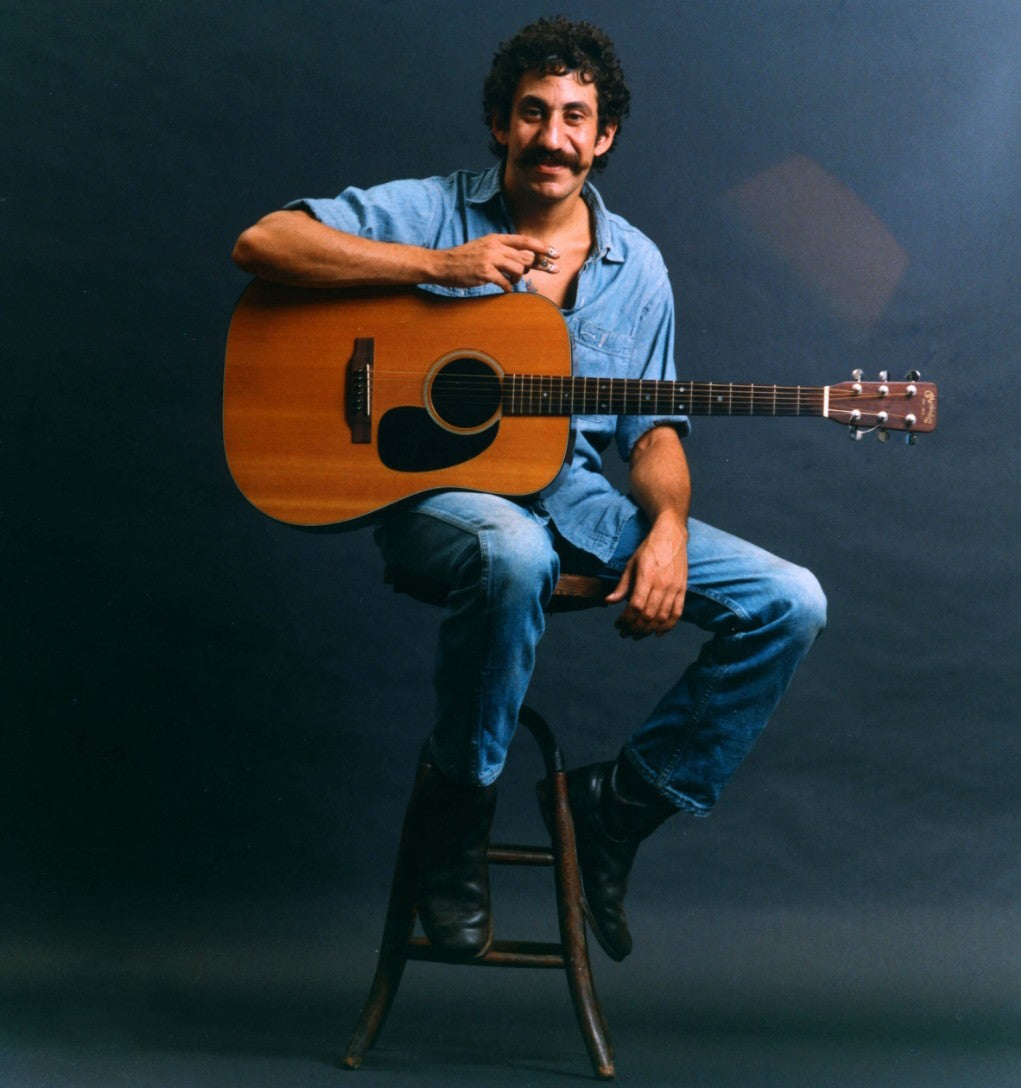 Jim Croce photos sitting on a stand with guitar
