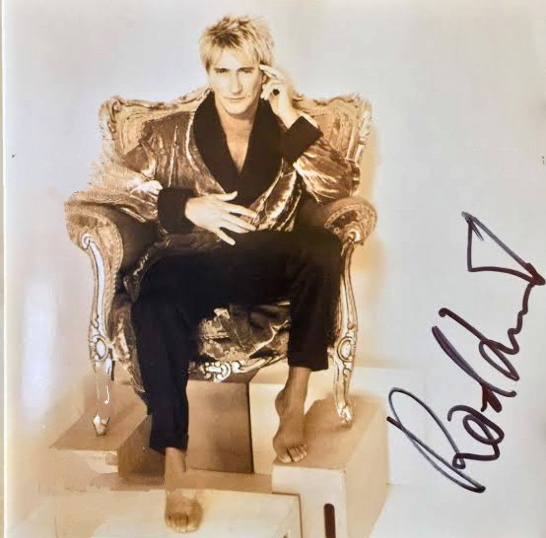 Rod Stewart signed photo sitting in King's chair arm up to side