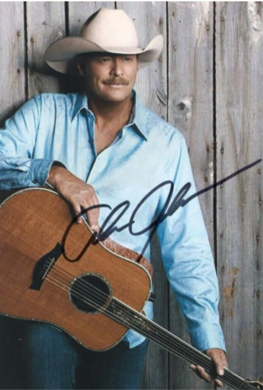 Alan Jackson signed photo leaning on wall with guitar