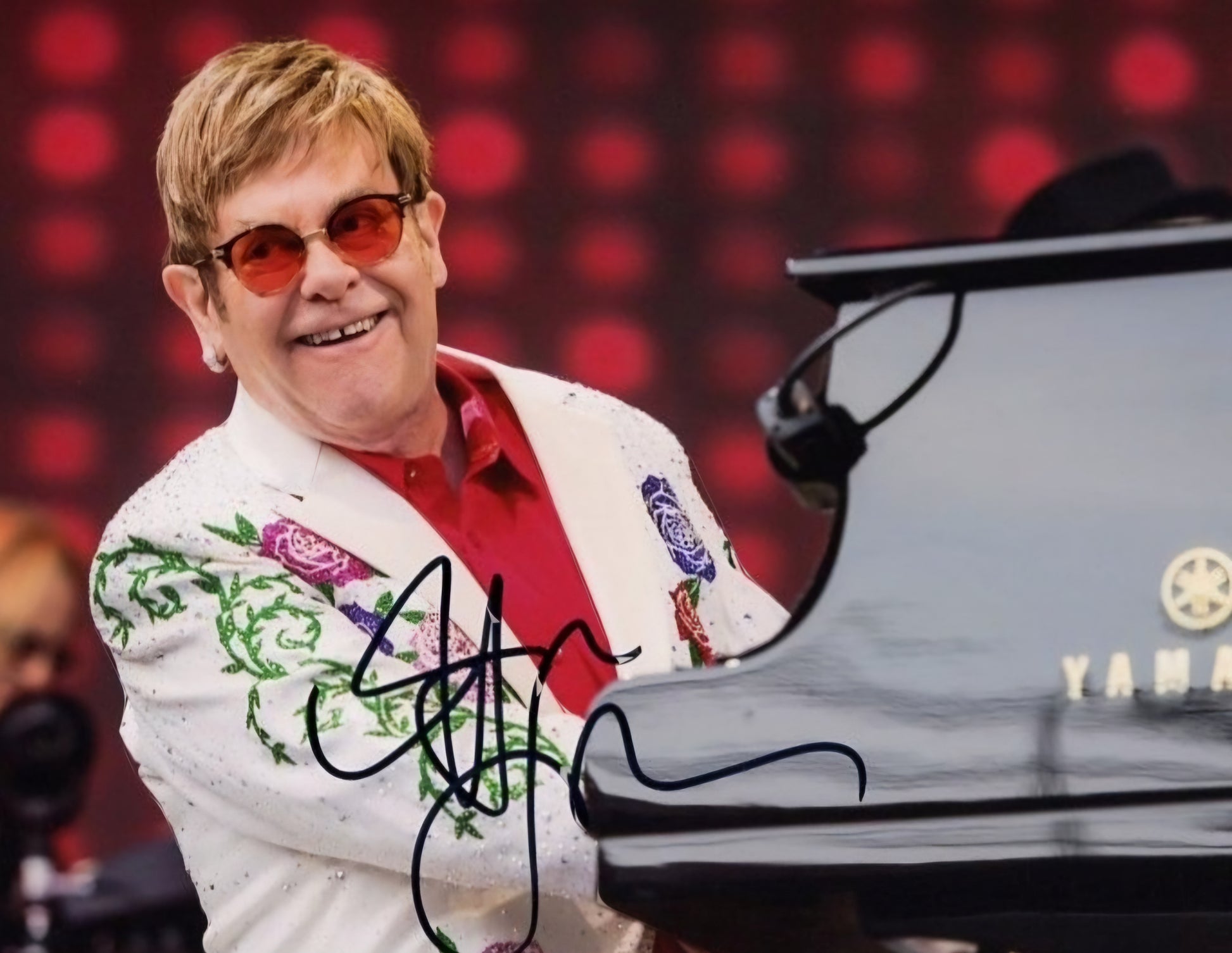 Elton John signed piano playing piano smiling on stage white jacket