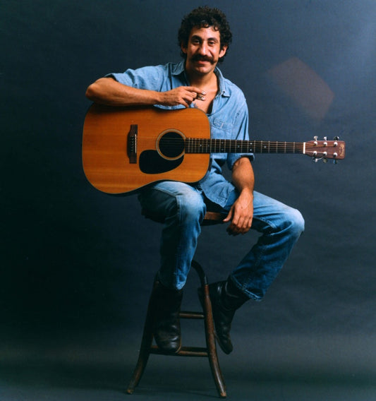 Jim Croce photos sitting on a stand with guitar