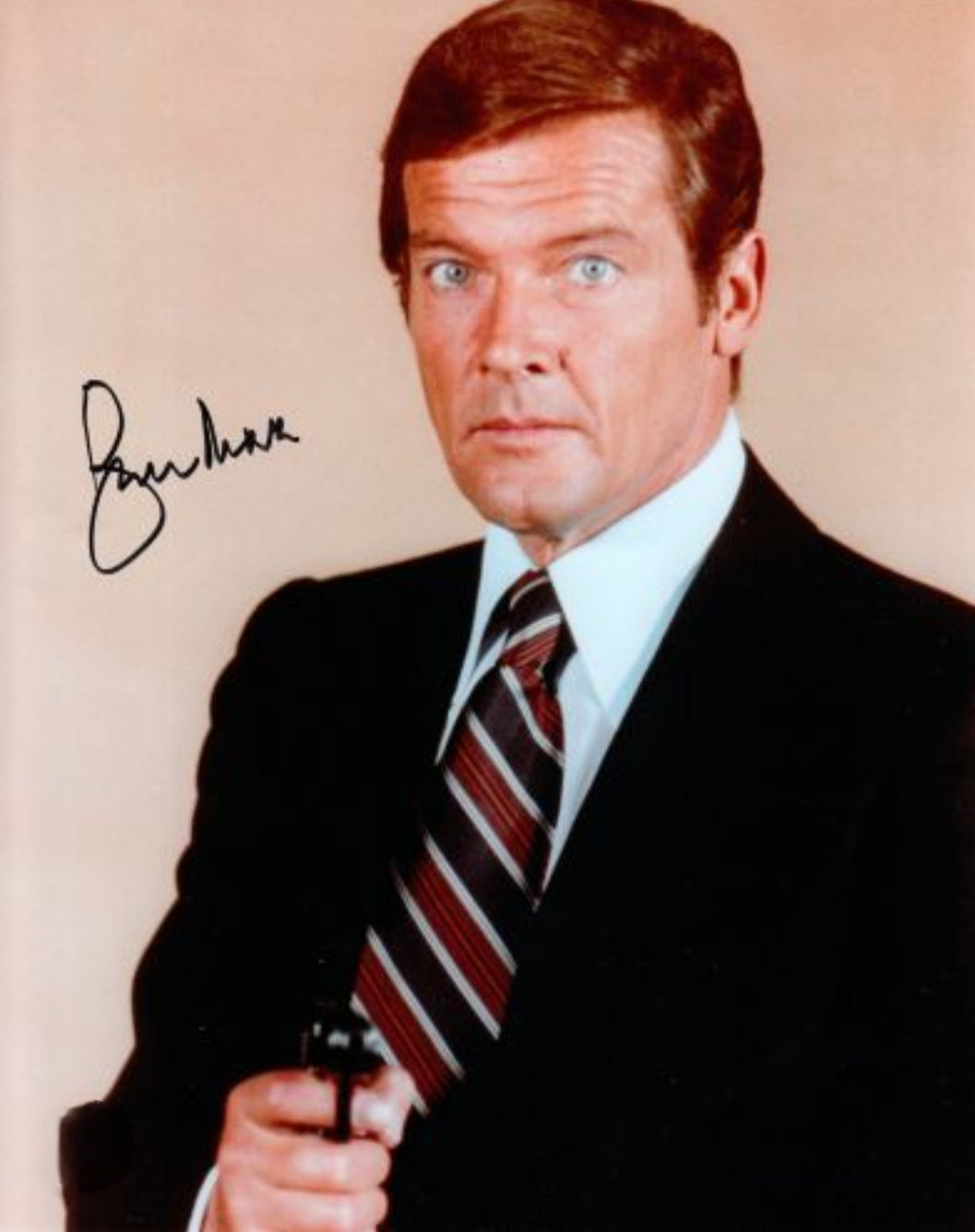 Roger Moore signed photo pointing a pistol in movie