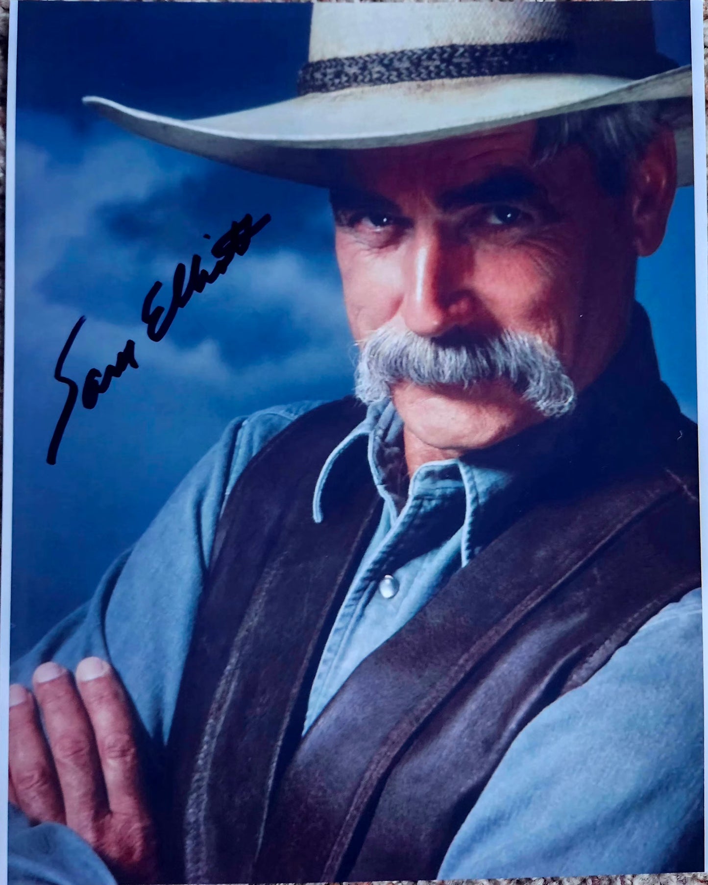 Sam Elliott signed photo black marker blue background