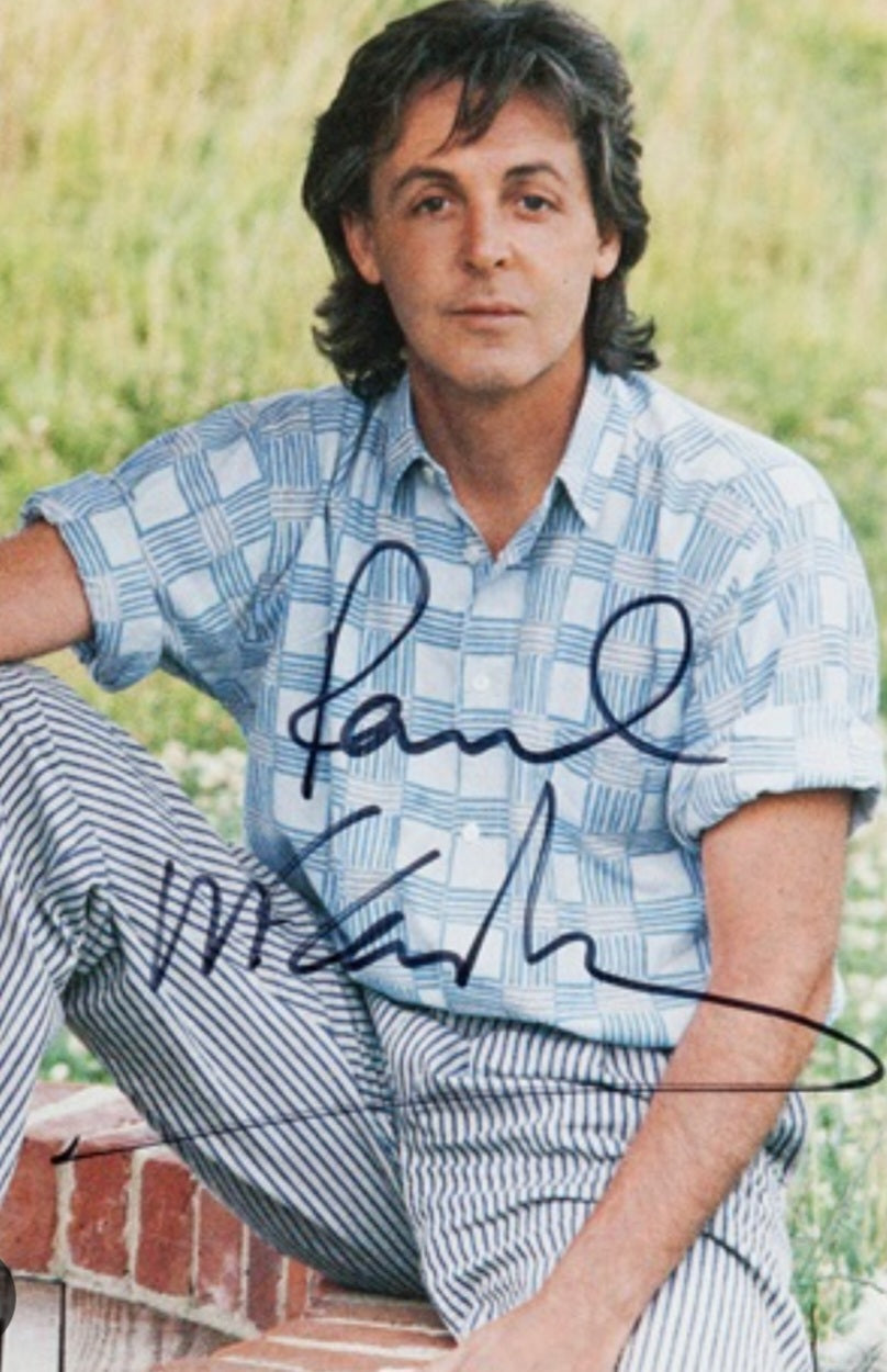 Paul McCartney signed photo sitting in a field